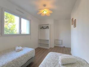 Les Dunes - Calme et Sérénité à 5 min de la Plage en voiture في Biville-sur-Mer: غرفة نوم بها سريرين ونافذة