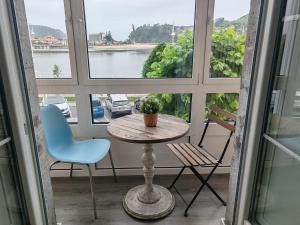a table and chairs in front of a window at alojamiento Premium Ribadesella Vistas al Mar in Ribadesella