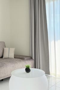 a white living room with a couch and a white table at The Sun Executive Suite - Dolphin's Home in Bayan Lepas