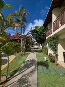 um passeio ao lado de um edifício com palmeiras em Solar Águas Pipa Stays em Pipa