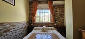 a small bedroom with a bed and a window at Apartamentos Wily y Mavi in San José