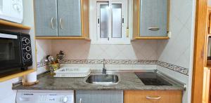 a small kitchen with a sink and a microwave at Apartamentos Wily y Mavi in San José +28 photos