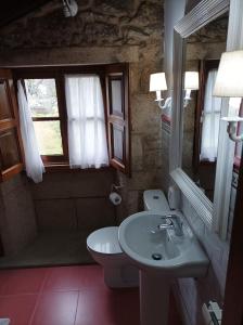 a bathroom with a sink and a toilet and a mirror at Hotel Vila As Pedras in Roxos +96 photos