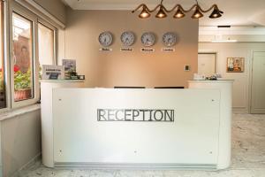 a reception desk in a room with clocks on the wall at Parliament Hotel & Restaurant in Baku