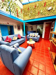 Una sala de estar con sofás azules y una mesa. en AITANA'S HOUSE - SAN BLAs, en Cusco