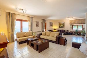 a living room with couches and a table at Seaview Villa Cleopatra - Private Pool & Tennis Court in Kalamos +57 photos