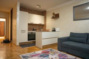 un soggiorno con divano e cucina di 111 Spot Apartment a Prizren Altre 7 foto