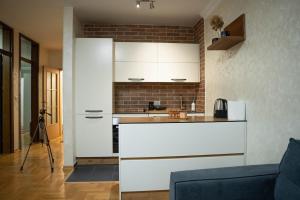 una cucina con mobili bianchi e un muro di mattoni di 111 Spot Apartment a Prizren