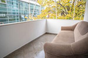 un divano su un balcone con finestra di 111 Spot Apartment a Prizren