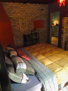 a large bed in a room with a brick wall at Refúgio Zakopane in Araucária +13 photos