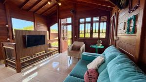 a living room with a blue couch and a tv at Pousada Astral in Imbituba