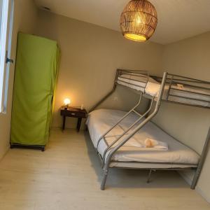 une chambre avec deux lits superposés et une lampe dans l'établissement Maison Chardonnerets - Poitiers, à Biard