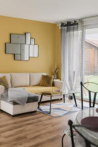un salon avec un canapé et une table dans l'établissement Maison Chardonnerets - Poitiers, à Biard