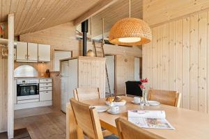 Feriehus 1143 في Nørby: مطبخ وغرفة طعام مع طاولة وكراسي
