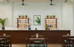 a restaurant with tables and a counter with a bartender at Green Morodoc Garden Hotel in Siem Reap