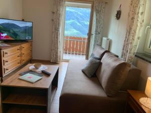 a living room with a couch and a table at Mareinhof - Urlaub auf dem Apfelbauernhof in Parcines