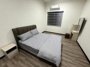 a small bedroom with a bed and a air conditioner at Hatasan Homestay Guess House in Perai