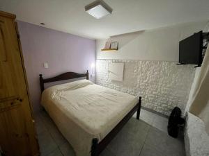 Luz de mar في سانتا كلارا ديل مار: غرفة نوم بها سرير وتلفزيون على الحائط