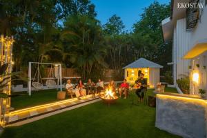 a group of people sitting around a fire in a backyard at Ekostay Luxe - CASA SIA - Ideal for Big Groups- Poker Table in Lonavala