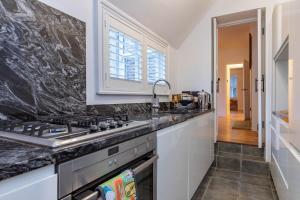 une cuisine avec une cuisinière et un évier dans l'établissement Stunning One Bed - Central Witney, à Eynsham