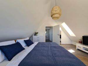 a bedroom with a large bed with blue pillows at Deichkoje in Westerdeichstrich