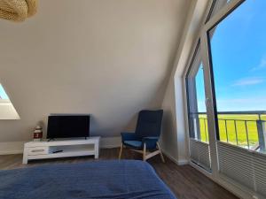 a bedroom with a bed and a tv and a window at Deichkoje in Westerdeichstrich