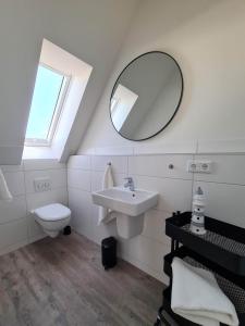 a white bathroom with a sink and a mirror at Deichkoje in Westerdeichstrich