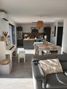 a living room with a table and a dining room at Location Saisonnière Villa in Uzès