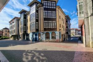 een lege stadsstraat met een groot gebouw bij Apartamento Vacacional La Rula in Llanes