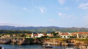 een boot in het water voor een stad bij Apartamento Vacacional La Rula in Llanes +6 foto's
