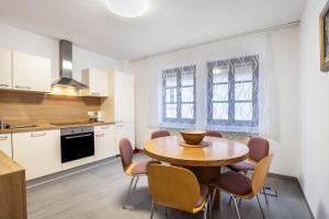 une cuisine et une salle à manger avec une table et des chaises en bois dans l'établissement Ferienwohnung Brunnenblick, à Pottenstein