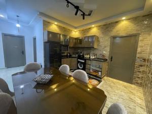 La Dolce Villa with Private Pool في برج العرب: مطبخ مع طاولة زجاجية وكراسي في غرفة +4 صور