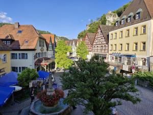 une vue d'une ville avec des bâtiments et une fontaine dans l'établissement Ferienwohnung Talblick, à Pottenstein