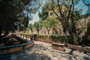 a walkway with a bench next to a stone wall at Casa Rural 5 Estrellas en Totana in Totana