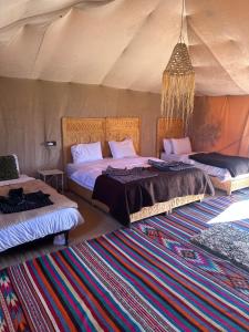 a bedroom with two beds in a tent at Le xury camp in Hassilabied