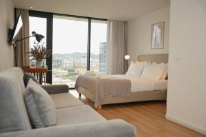 a hotel room with a bed and a couch at Rooftop Tirana in Tirana