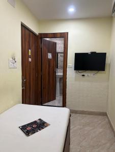 a room with a bed and a flat screen tv at Hotel Holiday Express in Kolkata