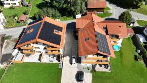 eine Aussicht auf ein Haus mit Sonnenkollektoren in der Unterkunft Ferienwohnungen Hipp - Bergblick und Wellness in Top Lage in Halblech + 55 Fotos