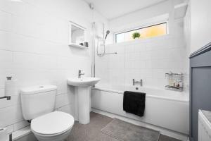 a white bathroom with a toilet and a sink at 4 Bedroom Town House Perfect for families or contractors Sleeps 8 in Halesowen +37 photos