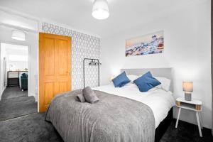 a bedroom with a large bed with blue pillows at 4 Bedroom Town House Perfect for families or contractors Sleeps 8 in Halesowen