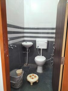a bathroom with a toilet and a sink at jp hotel and restorent in Rīngas