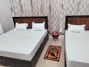 two beds sitting next to each other in a bedroom at jp hotel and restorent in Rīngas