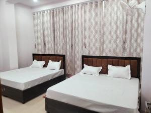 two beds sitting next to each other in a bedroom at jp hotel and restorent in Rīngas