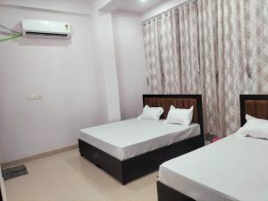 a bedroom with two beds and a window at jp hotel and restorent in Rīngas +8 photos