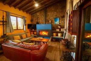 a living room with a couch and a fireplace at Casa Rural Sierra de Aguafría. Finca El Robledillo in Monesterio