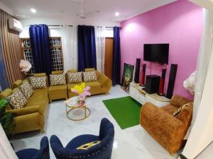 a living room with couches and a tv at Malaika White House Apartment & Spa in Kiwengwa
