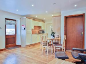 Horseshoe Cottage في Bolton by Bowland: مطبخ وغرفة طعام مع طاولة وكراسي