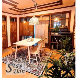una sala da pranzo con tavolo e sedie su un tappeto di 스테이단 