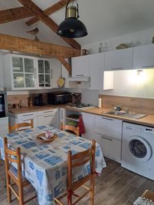 a kitchen with a table and chairs and a sink at Maison style chalet in Salles