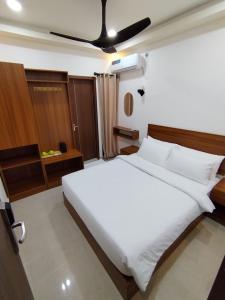 a bedroom with a large white bed with a ceiling at Handhuveli Dhangethi in Dhangethi